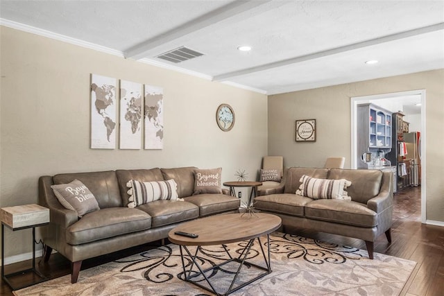 living area with visible vents, baseboards, beamed ceiling, ornamental molding, and hardwood / wood-style floors