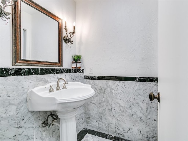 bathroom with a wainscoted wall and tile walls