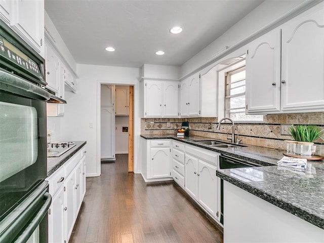 kitchen with dark wood-style flooring, white cabinetry, black appliances, and a sink