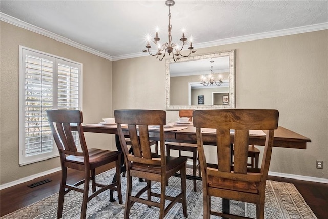 dining space with wood finished floors, visible vents, baseboards, crown molding, and a notable chandelier