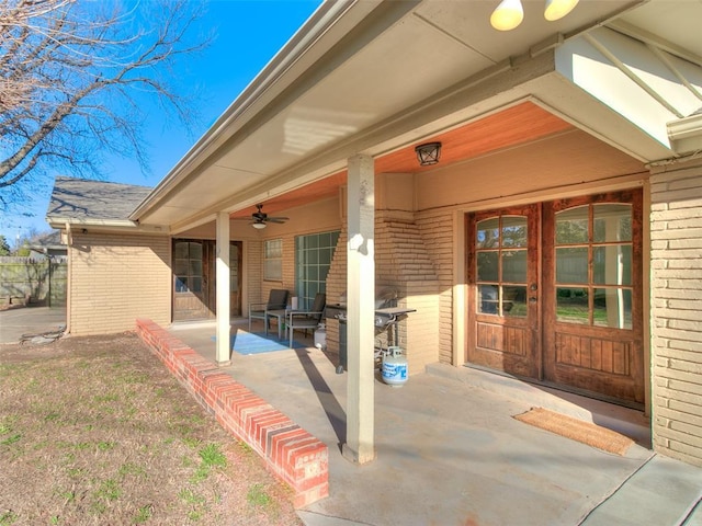 doorway to property with a ceiling fan, a patio area, french doors, and brick siding