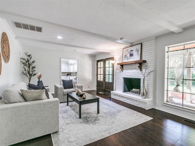 2900 Wilton Ln, Oklahoma City, OK 73120 - living area featuring beamed ceiling, wood-type flooring, baseboards, a brick fireplace, and french doors