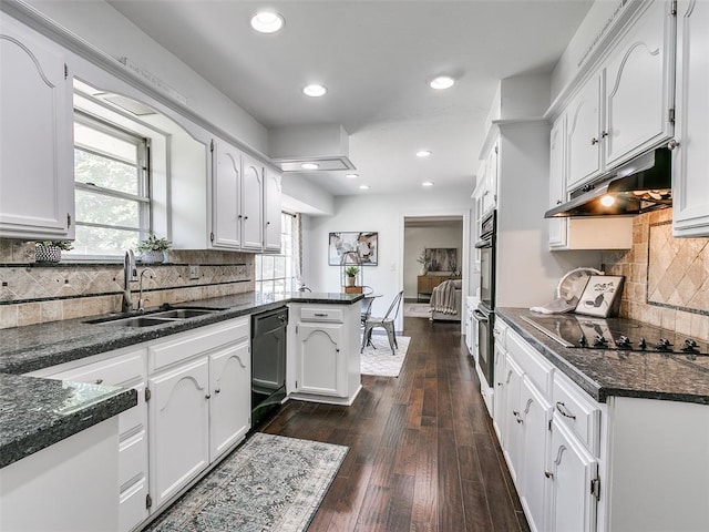 2900 Wilton Ln, Oklahoma City, OK 73120 - kitchen with under cabinet range hood, a sink, black appliances, a peninsula, and white cabinetry