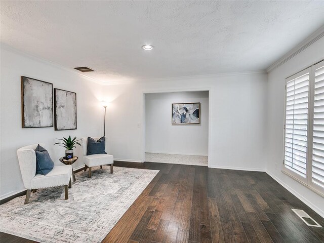 2900 Wilton Ln, Oklahoma City, OK 73120 - sitting room with dark wood-style floors, ornamental molding, baseboards, and a textured ceiling
