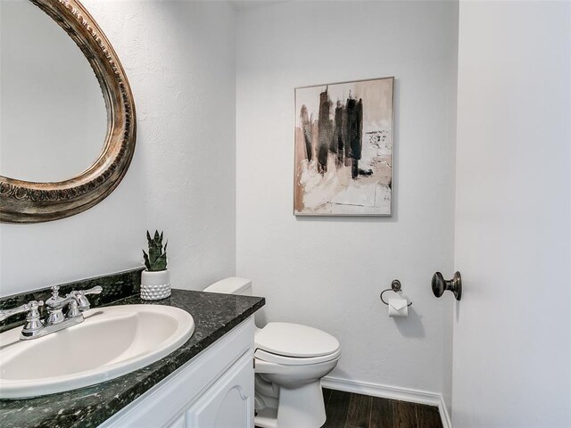 2900 Wilton Ln, Oklahoma City, OK 73120 - bathroom featuring wood finished floors, toilet, vanity, and baseboards