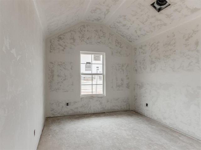 unfurnished room with vaulted ceiling