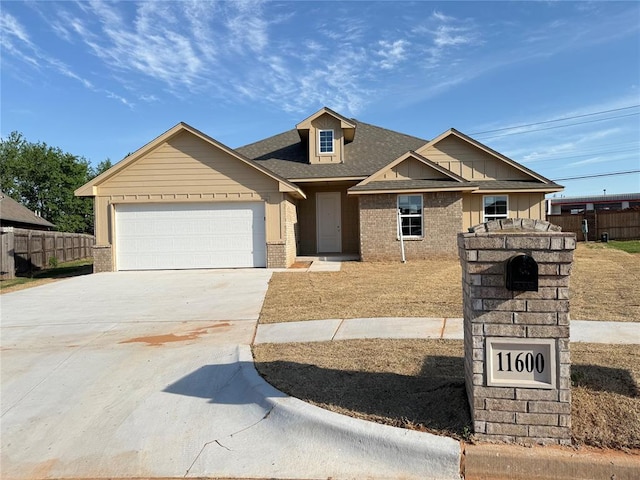 11600 SW 15th Ter, Yukon, OK 73099 - view of front facade with a shingled roof, an attached garage, fence, concrete driveway, and brick siding