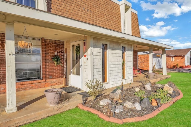 property entrance featuring brick siding and roof with shingles