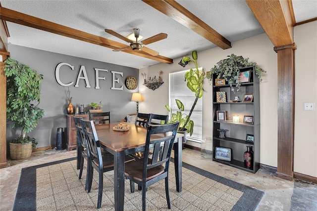 dining space featuring baseboards, a textured ceiling, and beamed ceiling