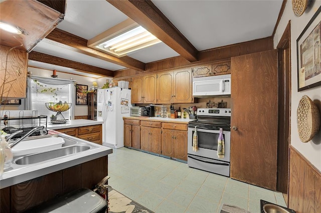 kitchen with beam ceiling, light countertops, brown cabinetry, a sink, and white appliances