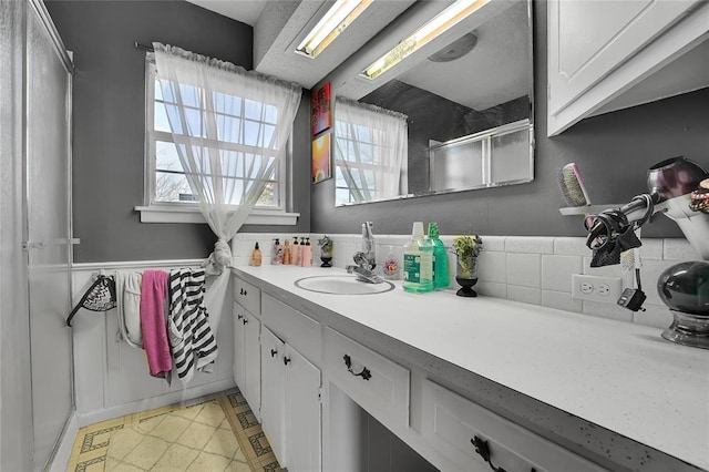 bathroom featuring a shower and vanity