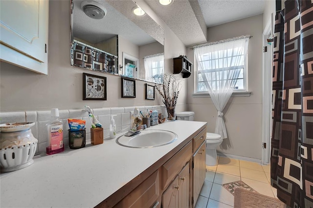 full bath featuring vanity, a textured ceiling, toilet, and tile patterned floors