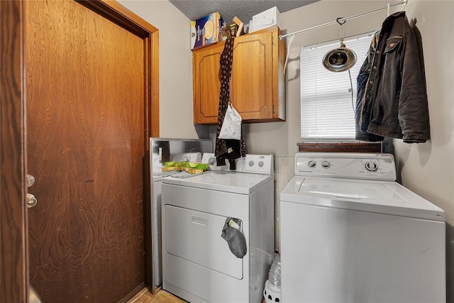 laundry room with cabinet space, washing machine and dryer, and a textured ceiling