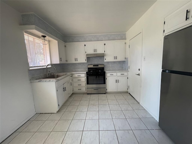 kitchen with under cabinet range hood, a sink, white cabinetry, appliances with stainless steel finishes, and backsplash