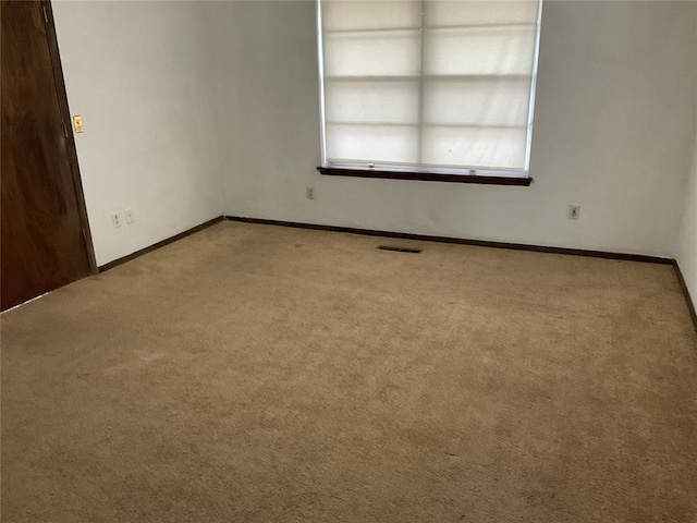 carpeted empty room with visible vents and baseboards