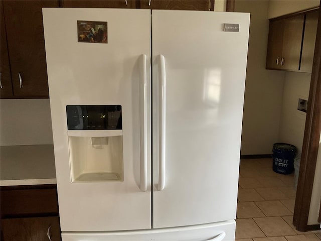 interior details featuring white refrigerator with ice dispenser and dark brown cabinetry