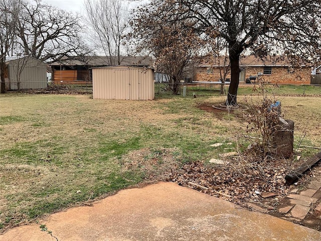 view of yard featuring a storage unit, an outdoor structure, and fence