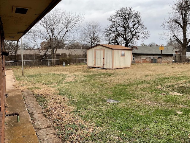 view of yard with an outbuilding, a fenced backyard, and a storage shed