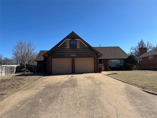 view of front facade featuring driveway, brick siding, an attached garage, and fence