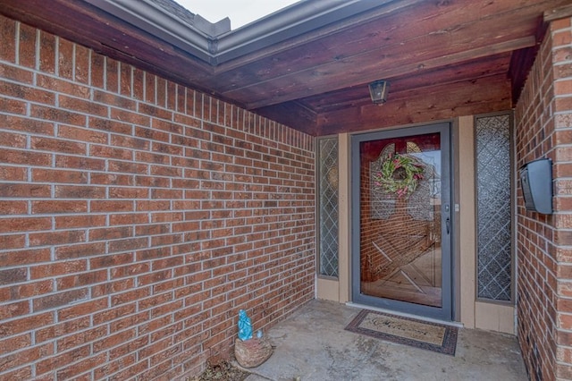 doorway to property with brick siding