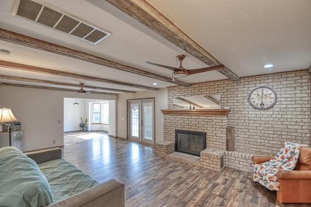 living area with ceiling fan, wood finished floors, and visible vents