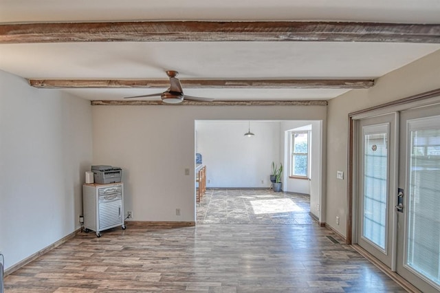 unfurnished room with baseboards, a ceiling fan, wood finished floors, french doors, and beam ceiling