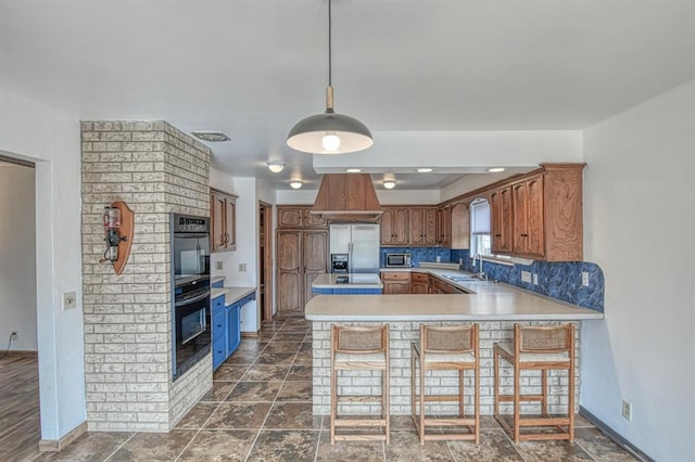 kitchen featuring visible vents, light countertops, decorative backsplash, appliances with stainless steel finishes, and a peninsula