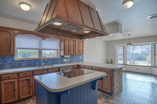 kitchen featuring a peninsula, black electric cooktop, decorative backsplash, and a sink