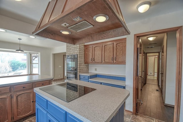 kitchen with blue cabinets, hanging light fixtures, light countertops, a center island, and black appliances