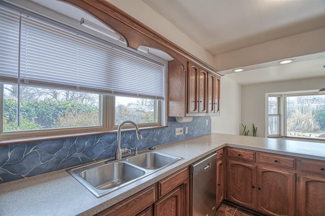 kitchen featuring stainless steel dishwasher, plenty of natural light, backsplash, and a sink