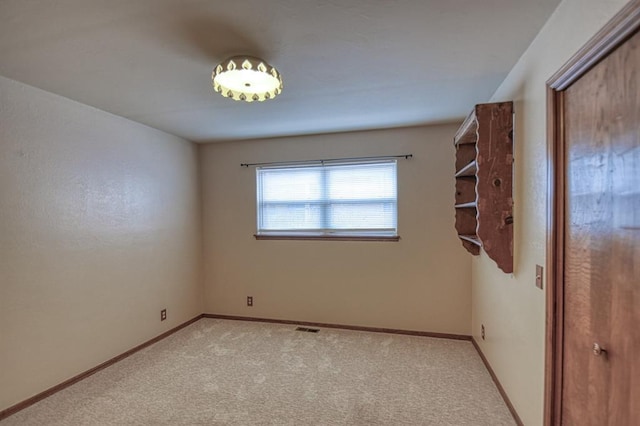 empty room featuring light carpet, baseboards, and visible vents