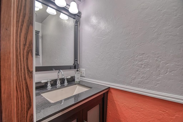 bathroom with a textured wall and vanity