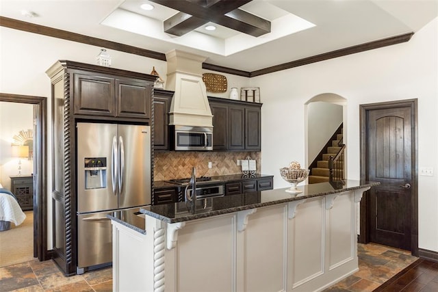 kitchen featuring stainless steel appliances, stone finish flooring, and a kitchen breakfast bar