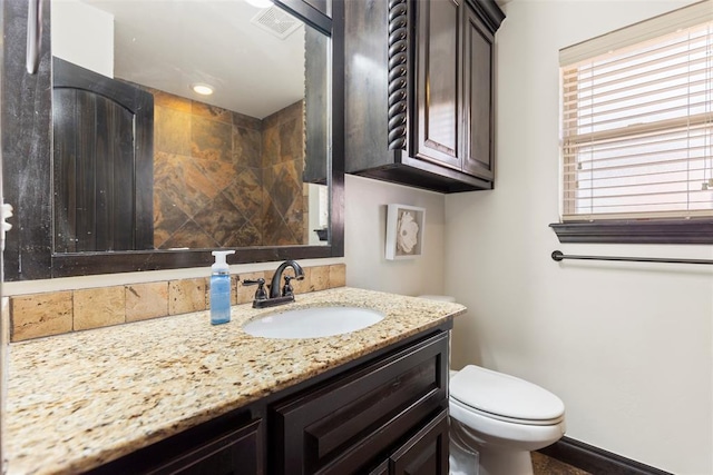 bathroom with baseboards, visible vents, vanity, and toilet