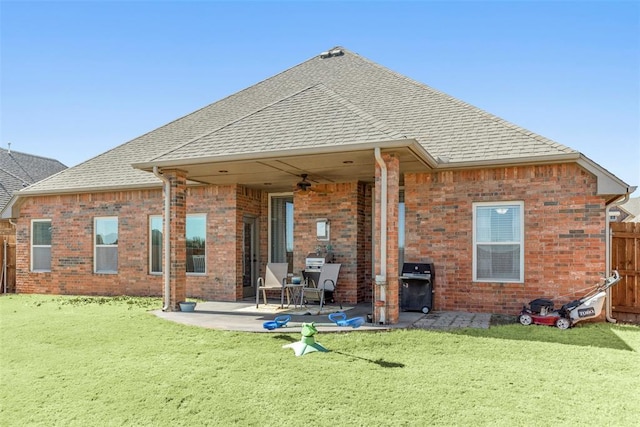 rear view of house with a patio, a shingled roof, a lawn, fence, and ceiling fan