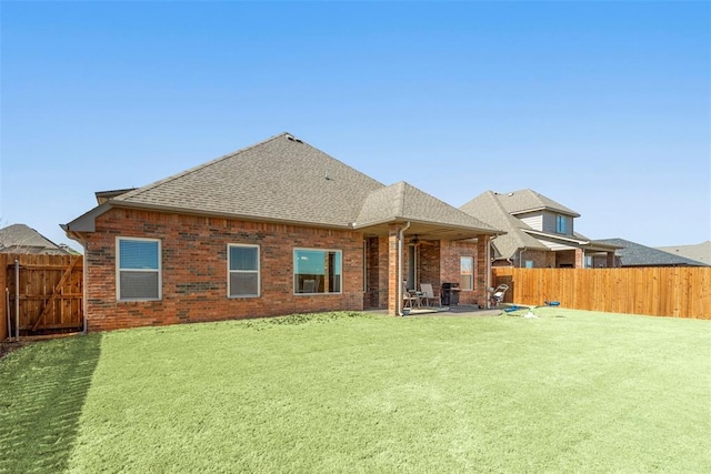 back of property featuring a fenced backyard, a patio, and brick siding