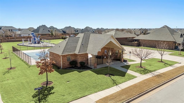 exterior space with brick siding, a front yard, fence, and a residential view