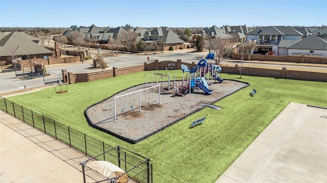 communal playground with a residential view, fence, and a yard