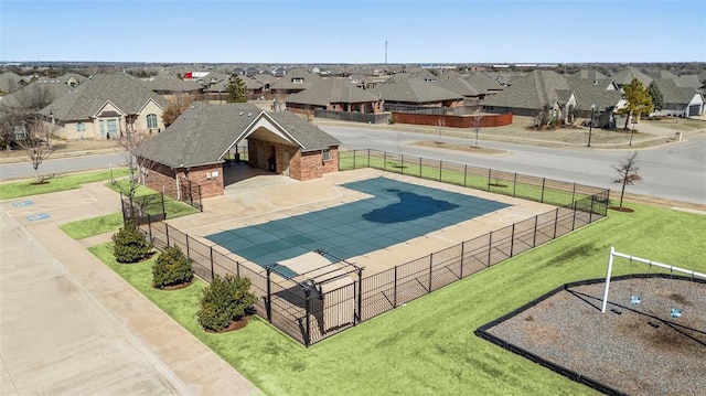 view of swimming pool with a yard, a residential view, and fence