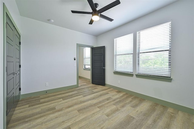 unfurnished bedroom featuring light wood-style flooring, baseboards, and ceiling fan