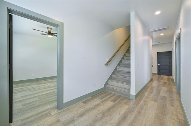 stairs with a ceiling fan, baseboards, visible vents, and wood finished floors