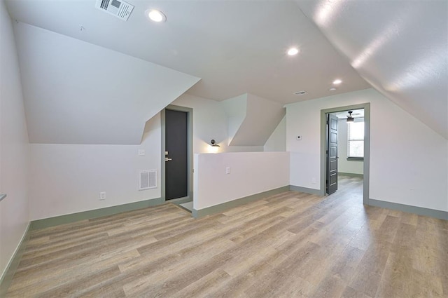 bonus room featuring light wood-style floors, lofted ceiling, and visible vents