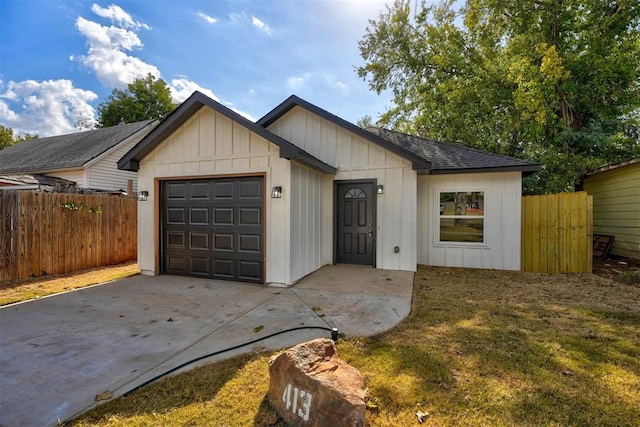 view of front of house featuring concrete driveway, roof with shingles, fence, and an attached garage