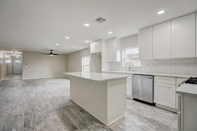 kitchen featuring a sink, light wood-style floors, visible vents, and stainless steel dishwasher