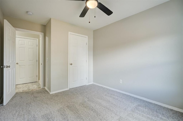 unfurnished bedroom featuring carpet, ceiling fan, and baseboards