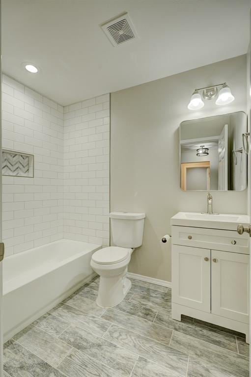 full bath with toilet, vanity, visible vents, baseboards, and tub / shower combination