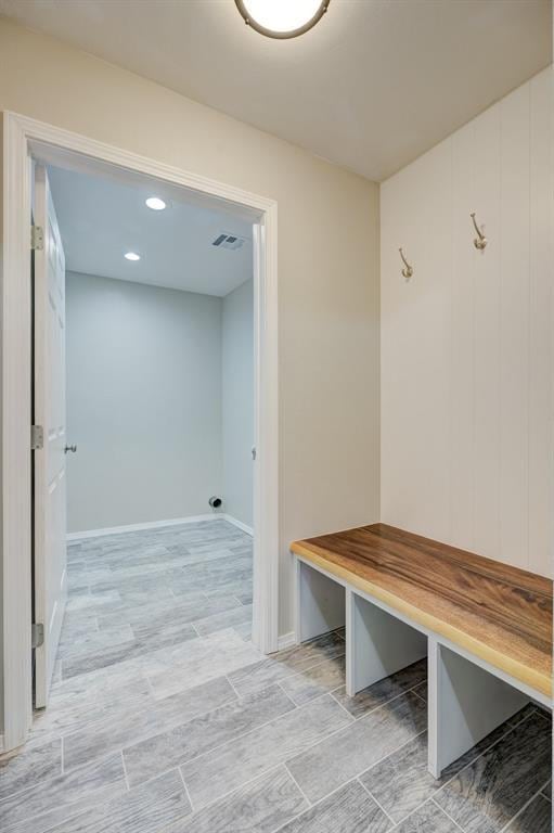 mudroom featuring baseboards, visible vents, and wood tiled floor