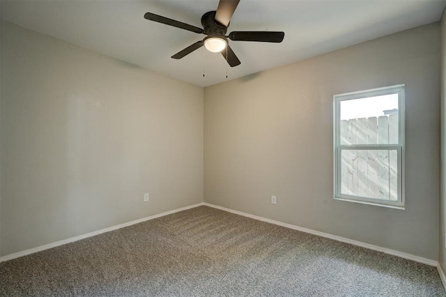 carpeted spare room with a wealth of natural light, ceiling fan, and baseboards