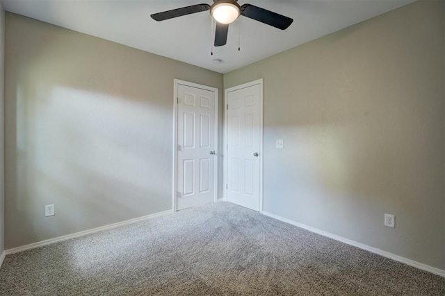 unfurnished room featuring carpet, a ceiling fan, and baseboards