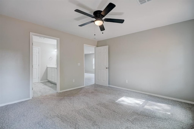 unfurnished bedroom featuring carpet, connected bathroom, a ceiling fan, and baseboards